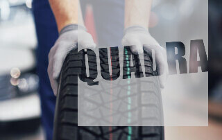 closeup-mechanic-hands-pushing-black-tire-workshop_146671-13581