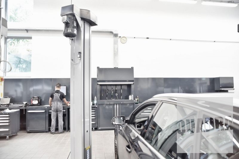 sistema di dispensing centralizzato installato in un'autofficina, sullo sfondo un meccanico che lavora