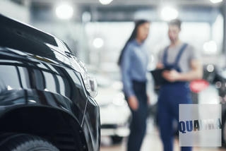 meccanico e cliente che si trovano in una autofficina realizzata da Quadra, in primo piano una macchina