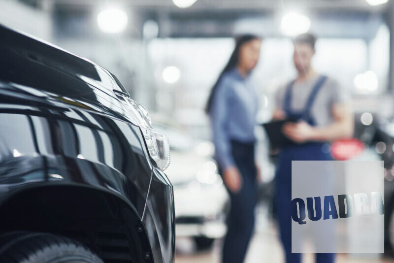 meccanico e cliente che si trovano in una autofficina realizzata da Quadra, in primo piano una macchina